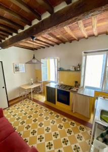 a living room with a kitchen with a red couch at Alle Casine in Lucca +7 photos