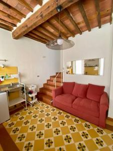 a living room with a red couch and a staircase at Alle Casine in Lucca