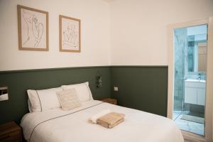 a bedroom with a white bed with two towels on it at Luxury units by Hilton beach in Tel Aviv