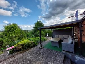 a patio with a couch and a table and chairs at Ferienhaus Eifel Nature Dream in Dockweiler