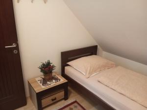 a small bedroom with a bed and a table at Villa Pahuljica in Jahorina