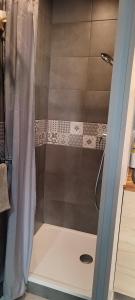 a shower with a shower curtain in a bathroom at Mauguio Center Hôtel in Mauguio