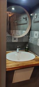 a bathroom with a white sink and a mirror at Mauguio Center Hôtel in Mauguio