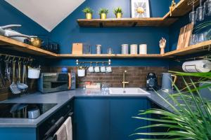 a kitchen with blue walls and a sink at The Former New Inn in Ashby de la Zouch