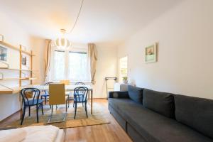 sala de estar con sofá, mesa y sillas en Vienna Lights Apartments - Apartment Park View, en Viena