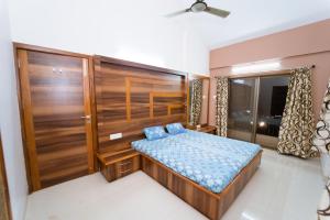 a bedroom with a bed and a large wooden door at The Royal Villa in Panchgani