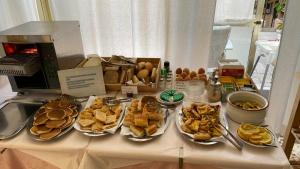 una mesa con varios platos de comida. en Albergo Fiorenza & Banksia Meublè, en Alassio