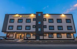 a large building with a sign on the side of it at شقق درة النخيل للشقق المخدومة Durat Alnakheel Serviced Apartments in Unayzah