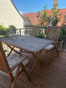 una mesa de picnic de madera y 2 sillas en una terraza en Hej Ferienwohnung, en Gau-Algesheim