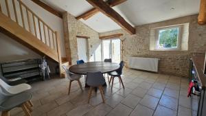 a dining room with a wooden table and chairs at Le gîte de Malécot Gîte familial de 5 personnes in Coulon