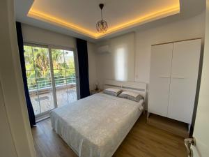 a bedroom with a bed and a large window at Orange&Lemon Villas Çamyuva in Kemer