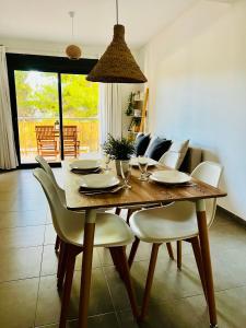 ein Esszimmer mit einem Tisch und weißen Stühlen in der Unterkunft Apartamento en la playa in Calafat
