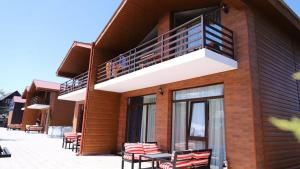 a building with a balcony with tables and chairs at Star Villa Bakuriani in Bakuriani