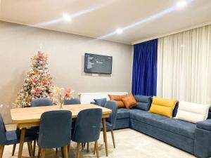 a living room with a blue couch and a christmas tree at Star Villa Bakuriani in Bakuriani