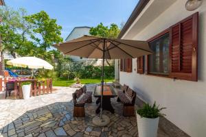 une terrasse avec une table et un parasol dans l'établissement Holiday Homes in Porec - Istrien 42537, à Poreč