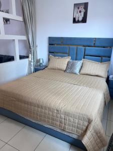 a bed with a blue headboard in a bedroom at Reem 1 in Ajman 