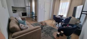 uma sala de estar com um sofá, cadeiras e uma mesa em Stylish, luxurious 2-bedroom apt em Paralimni