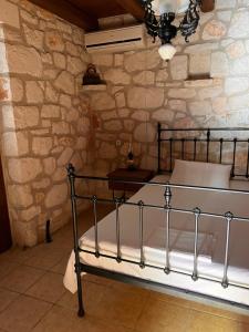 a bedroom with a bed in a stone wall at Gloria Holiday Homes Apartments in Lithakia