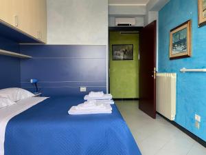 een slaapkamer met een blauw bed en handdoeken bij La Casa di Tamy in Boville Ernica