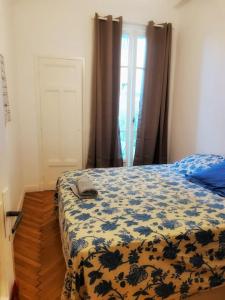 ニースにあるDolce bilocale con terrazzoのベッドルーム1室(青い花の毛布付きのベッド1台付)