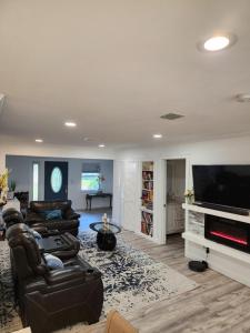 sala de estar con muebles de cuero y TV de pantalla plana en Spacious Bedroom with private workspace, ensuite bathroom - Room# 1 in SHARED house NO PET en Orlando