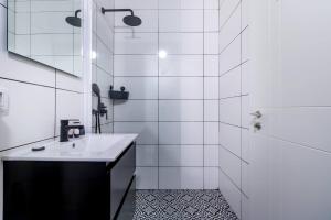 een witte badkamer met een wastafel en een douche bij Sheva Urban Suites in Jeruzalem