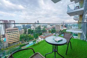 a table and chairs on a balcony with a view of a city at 2Bedroom Luxury Apartment, Skynest Residences, Westlands in Nairobi