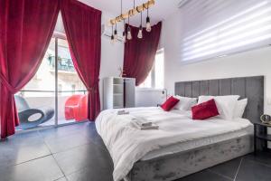 - une chambre avec un grand lit et des rideaux rouges dans l'établissement Sheva Urban Suites, à Jérusalem