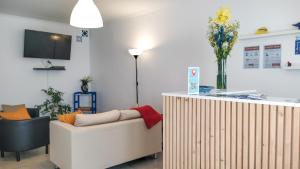 a living room with a couch and a vase of flowers at Ó da Casa in Peniche