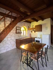 a kitchen with a wooden table in a room at Gloria Holiday Homes Apartments in Lithakia