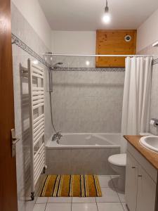 a bathroom with a tub and a toilet and a sink at Appartement Spacieux au Pays du Mont-Blanc in Sallanches