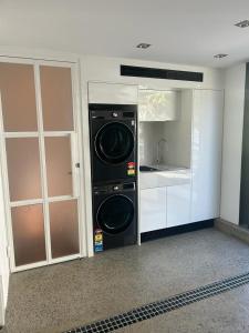 雪梨的住宿－Woollahra house beautiful 3 bedroom terrace，一间厨房,在房间内配有洗衣机和烘干机