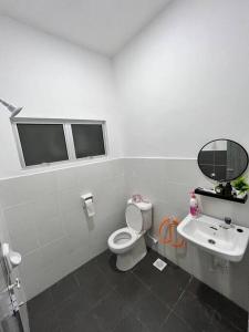 ein Bad mit einem WC und einem Waschbecken in der Unterkunft Zh homestay teluk batik in Lumut