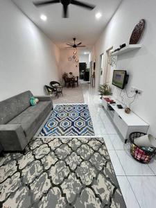 ein Wohnzimmer mit einem Sofa und einem Esszimmer in der Unterkunft Zh homestay teluk batik in Lumut