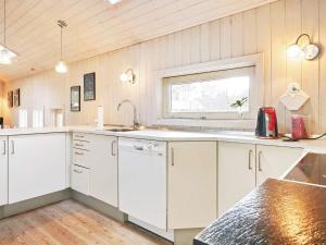 een keuken met witte kasten en een raam bij 8 person holiday home in Nex in Vester Sømarken