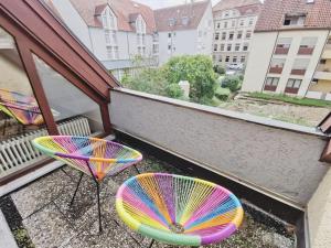 two colorful chairs and tables on a balcony at CASA HARMONY - Zentral-Uni-Bahnhof-Balkon-Unique-SmartTV in Nürtingen
