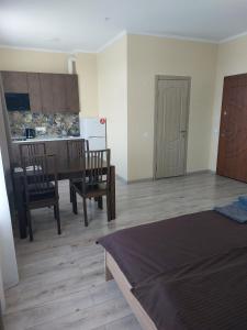 Zimmer mit einem Bett und einer Küche mit einem Tisch und Stühlen in der Unterkunft Сity Business Apart in Kropywnyzkyj