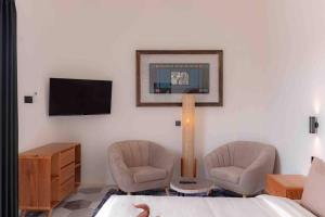 un salon avec deux chaises et une télévision dans l'établissement Spacious Design Villa 3bd, à Canggu