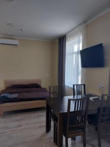 1 dormitorio con 1 cama, mesa y sillas en Сity Business Apart, en Kropyvnytskyi