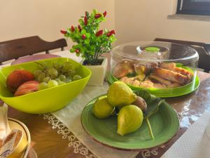 una mesa con platos de comida y un bol de fruta en Upupa B&B Casa Vacanza, en Sessa Cilento