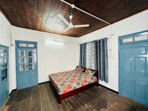 a bedroom with a bed and two doors at Levi Home Guest House & Retreat Centre in Siliguri +9 photos