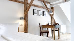 um quarto com uma cama, uma secretária e uma mesa em Apartments am Dom em Naumburg