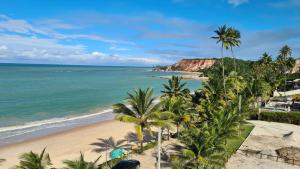 a beach with palm trees and the ocean at Luxor Tabatinga Beira Mar in Conde