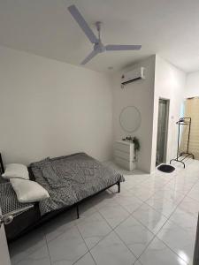- une chambre avec un lit et un ventilateur de plafond dans l'établissement Zh homestay teluk batik, à Lumut
