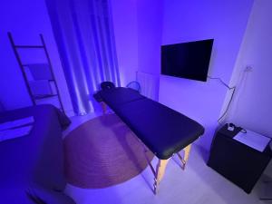 Dieses lila Zimmer verfügt über einen Tisch und einen TV. in der Unterkunft Guest Room Bien-être et cosy près de Paris, Roissy CDG et du village Olympique in Persan