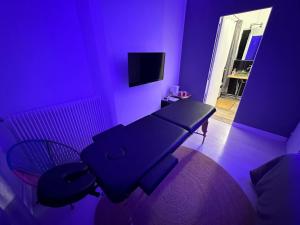 ein lila Zimmer mit einem Tisch und einem Stuhl in der Unterkunft Guest Room Bien-être et cosy près de Paris, Roissy CDG et du village Olympique in Persan