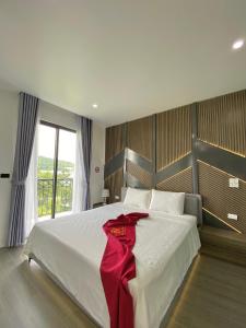 Un dormitorio con una cama grande con una cinta roja. en Villa 7PN sát biển tại Hạ Long en Ha Long