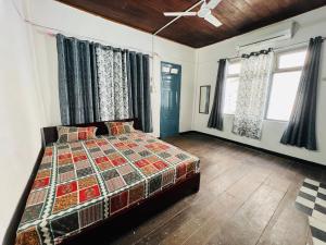 a bedroom with a bed and a ceiling fan at Levi Home Guest House & Retreat Centre in Siliguri