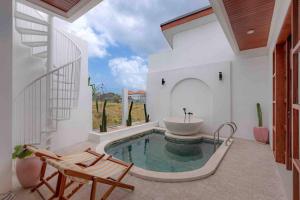 ein Badezimmer mit Badewanne und Waschbecken in einem Zimmer in der Unterkunft Modern Tropical Escape 1bd in Canggu