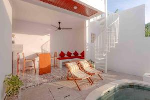 ein Haus mit einem Pool, einem Tisch und Stühlen in der Unterkunft Modern Tropical Escape 1bd in Canggu